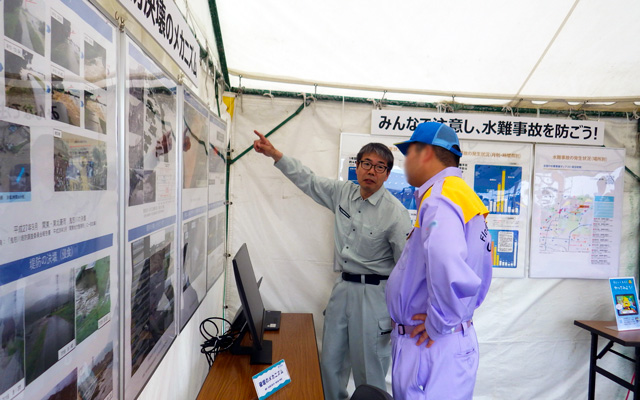 河川財団展示ブースで来場者に説明中